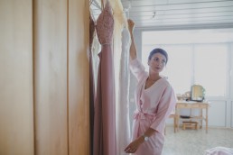 Die Schwester der Braut beim Abhängen der Kleider für eine Weinguthochzeit in Würzburg festgehalten von Hochzeitsfotografin Conny Schöffmann Photography, Würzburg