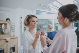 Braut mit ihrer Schwester beim Getting Ready vor ihrer Weingut-Hochzeit festgehalten von Hochzeitsfotografin Conny Schöffmann Photography, Würzburg