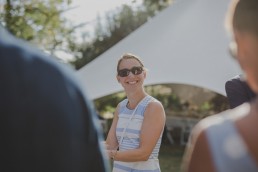 Glücklicher Gast einer Zelthochzeit unter freiem Himmel fotografiert von Würzburger Hochzeitsfotografin Conny Schöffmann Photography