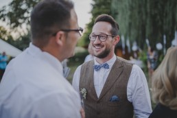 Bräutigam plaudert entspannt unter freiem Himmel mit seinen Gästen fotografiert von Würzburger Hochzeitsfotografin Conny Schöffmann Photography
