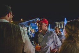 Lockerer Gast plaudert mit dem Brautpaar unter freiem Himmel in Würzburg festgehalten von Hochzeitsfotografin Conny Schöffmann Photography, Würzburg