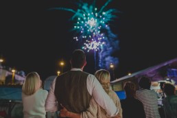 Brautpaar beobachtet eng umschlungen das stimmungsvolle Feuerwerk einer Stadtstrandhochzeit in Würzburg festgehalten von Hochzeitsfotografin Conny Schöffmann Photography, Würzburg