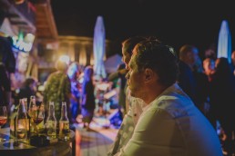 Stimmungsvolle Gäste beobachten das rege Partytreiben einer Stadtstrandhochzeit in Würzburg festgehalten von Hochzeitsfotografin Conny Schöffmann Photography, Würzburg