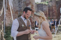 Stimmungsvolles Anstecken der Ringe bei einer Ruinenhochzeit im Freien fotografiert von Würzburger Hochzeitsfotografin Conny Schöffmann Photography