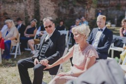 Emotional ergriffene Gäste verfolgen die Outdoorhochzeit in einer Ruine festgehalten von Hochzeitsfotografin Conny Schöffmann Photography aus Würzburg