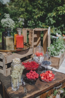 Liebevoll arrangierte Snacks auf einem alten Holztisch unter freiem Himmel fotografiert von Würzburger Hochzeitsfotografin Conny Schöffmann Photography