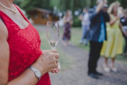 Entspannter Gast hält Sektglas in der Hand auf einer Zelthochzeit in Würzburg fotografiert von Hochzeitsfotografin Conny Schöffmann Photography, Würzburg