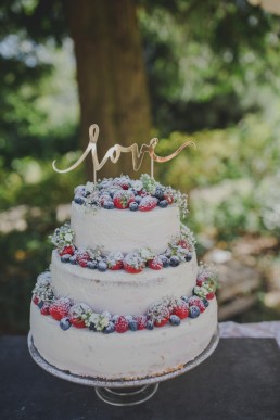 Natürlich dekorierte Hochzeitstorte unter freiem Himmel einer Zelthochzeit in Würzburg festgehalten von Hochzeitsfotografin Conny Schöffmann Photography, Würzburg