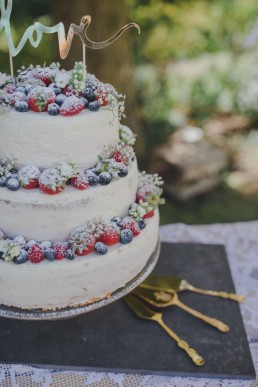 Leckere Hochzeitstorte dekoriert mit Beeren einer Ruinenhochzeit in Würzburg festgehalten von Hochzeitsfotografin Conny Schöffmann Photography, Würzburg