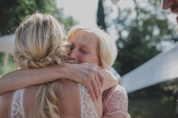 Emotionale Umarmung zwischen Gast und Braut auf einer Zelthochzeit im Freien fotografiert von Würzburger Hochzeitsfotografin Conny Schöffmann Photography