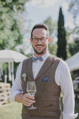 Entspannter Bräutigam mit Sektglas in der Hand einer Ruinenhochzeit in Würzburg festgehalten von Hochzeitsfotografin Conny Schöffmann Photography, Würzburg